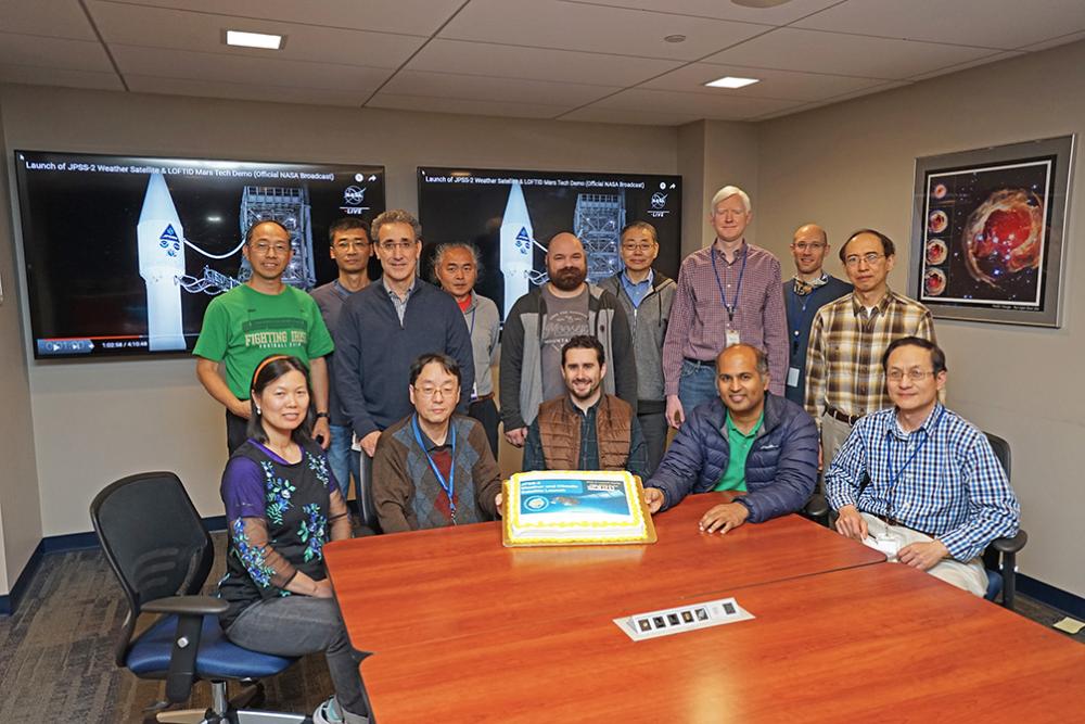 SSAI employees gathered around a cake